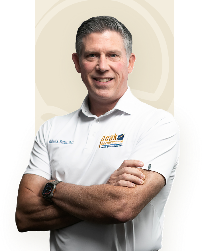 Dr. Robert Barton, arms crossed, in a Peak Performance clinic polo
